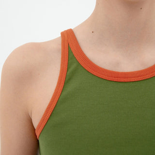 Green tank top with orange trim worn by a person on a white background