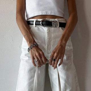 Person wearing a white crop top and light-colored pants against a plain background